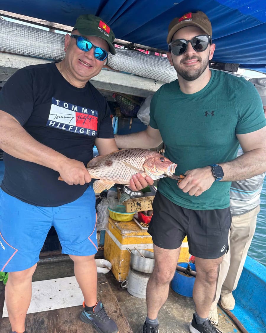 Two guests holding a fish caught on a Nha Trang fishing tour