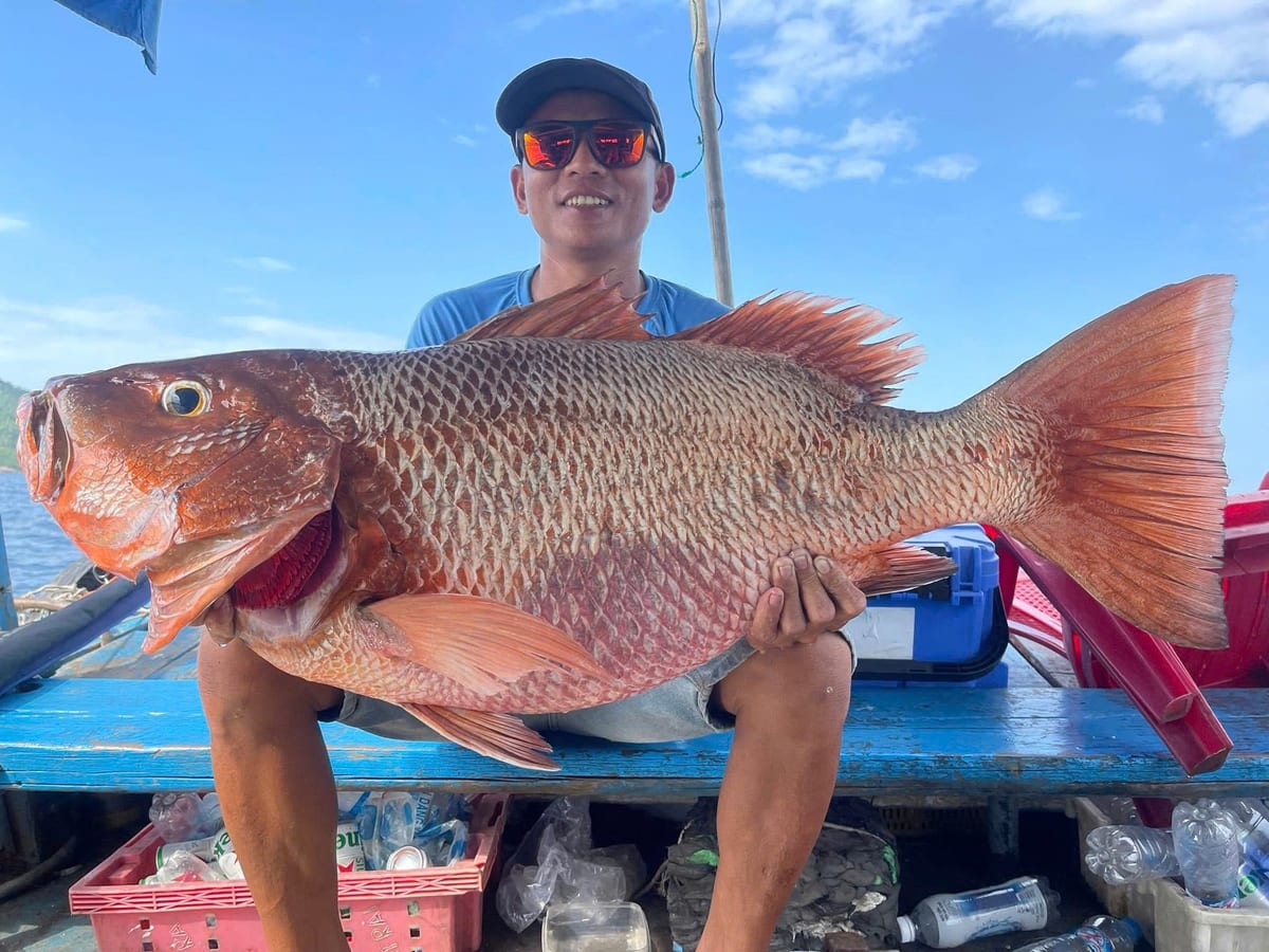 Guest holding a large red snapper caught on a big game fishing trip in Nha Trang