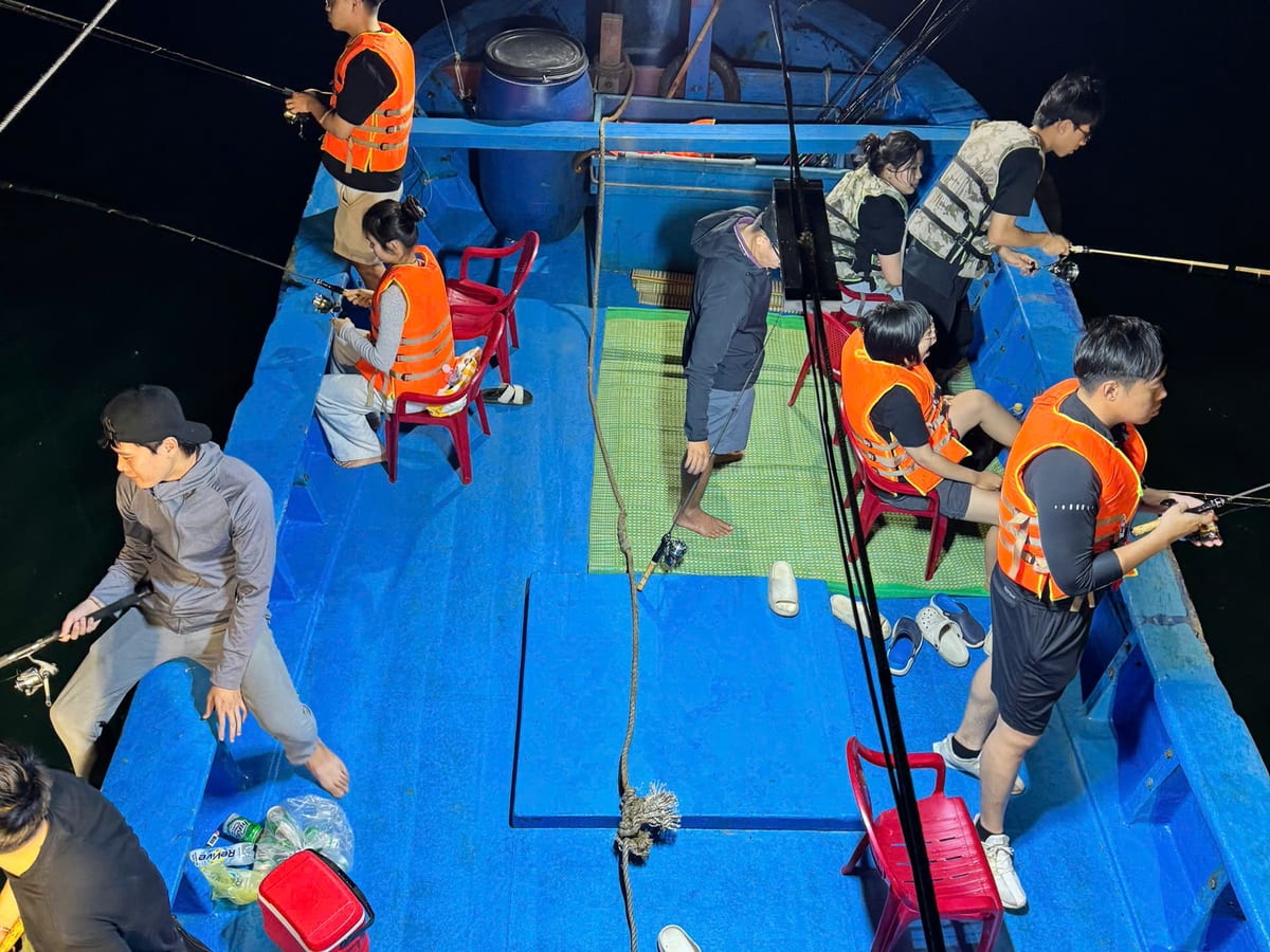 Guests squid fishing along the rail under the boat floodlights at night off Nha Trang